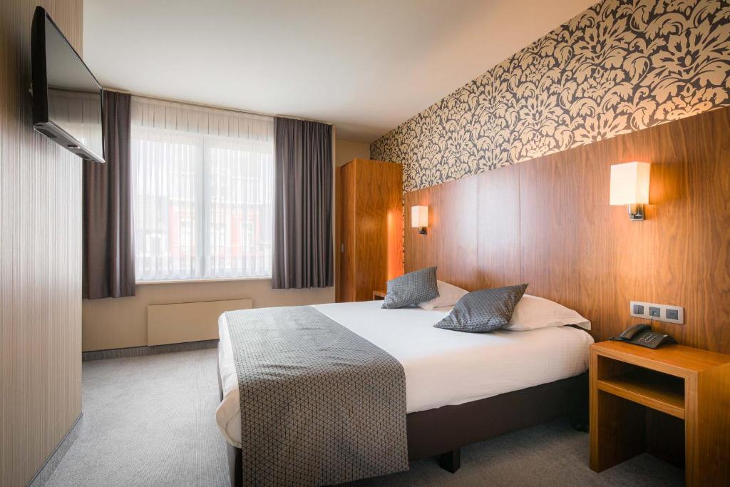 a hotel room with a bed and a window at Hotel Chamade in Ghent