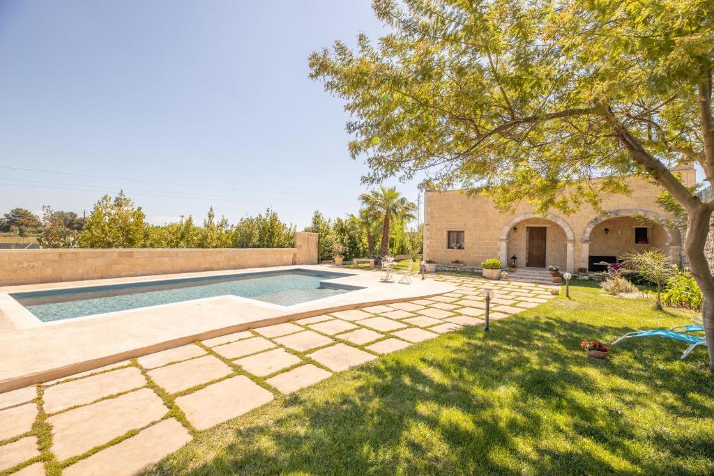 a backyard with a swimming pool and a yard at Villa Funny in Carpignano Salentino