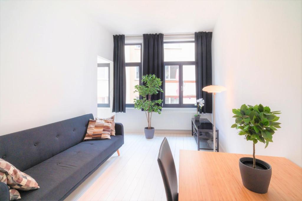 een woonkamer met een blauwe bank en een tafel bij Beautiful Cozy Cityflats in the Centre of Antwerp in Antwerpen