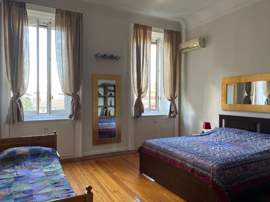米蘭的住宿－Sant'Ambrogio with charme，一间卧室设有两张床、镜子和窗户。
