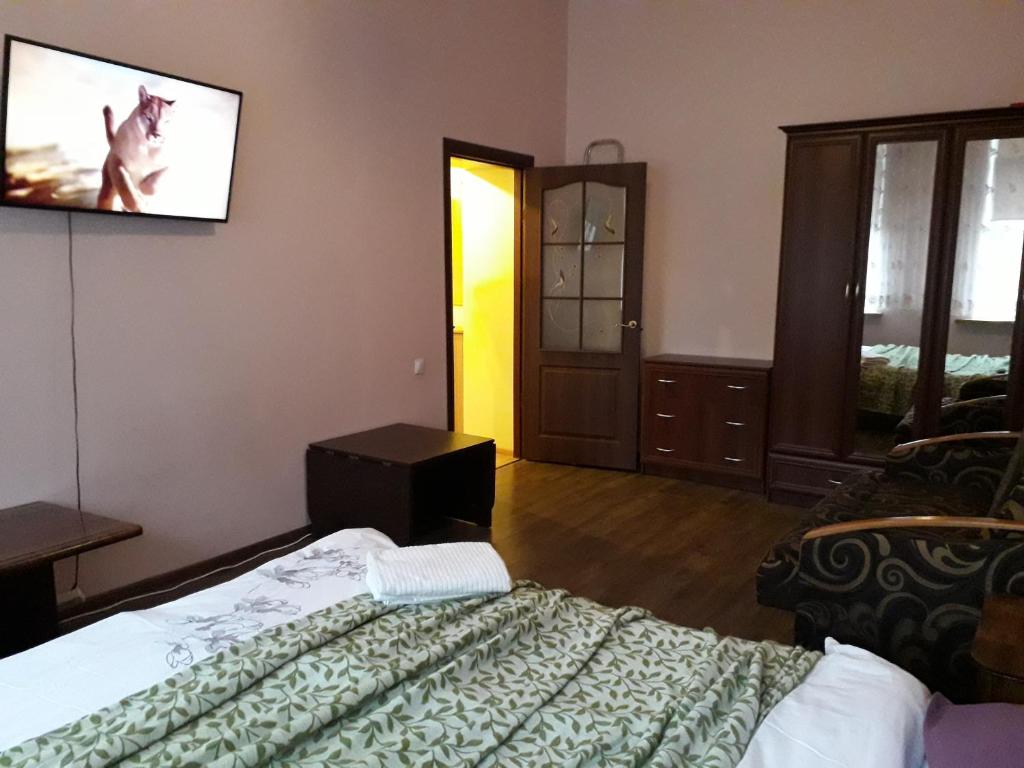 a bedroom with a bed and a tv on the wall at Cietokšņa 34 in Daugavpils