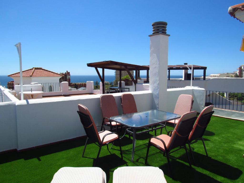 a patio with a table and chairs on a roof at Lomas de Mena in Benalmádena