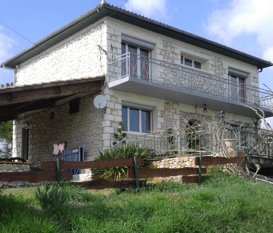 una casa de piedra con una valla delante de ella en Chambre leo, en Xaintrailles