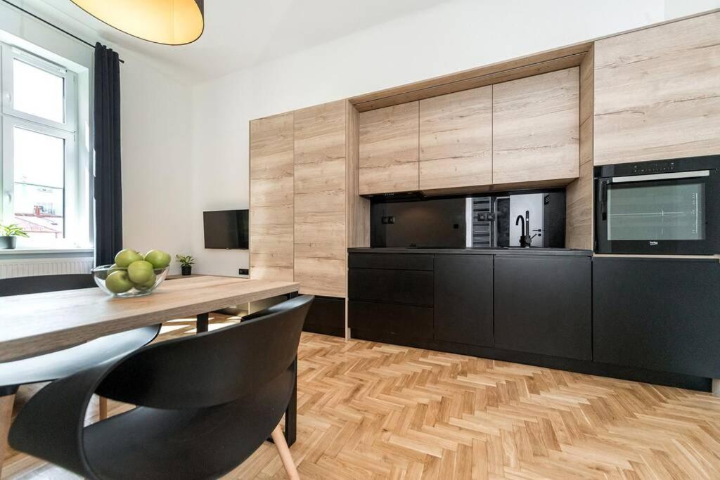 a dining room with a table and a television at Apartament Matejki E in Bielsko-Biała