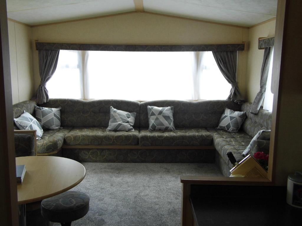 a living room with a couch with pillows on it at Oakdene -3 Bedroom Caravan in Weeley