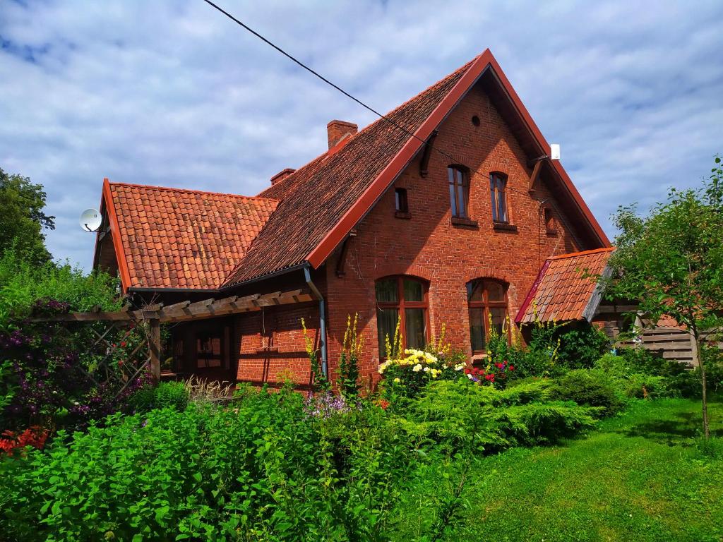 a brick house with a red roof at Leśniczówka Zawilec in Budry