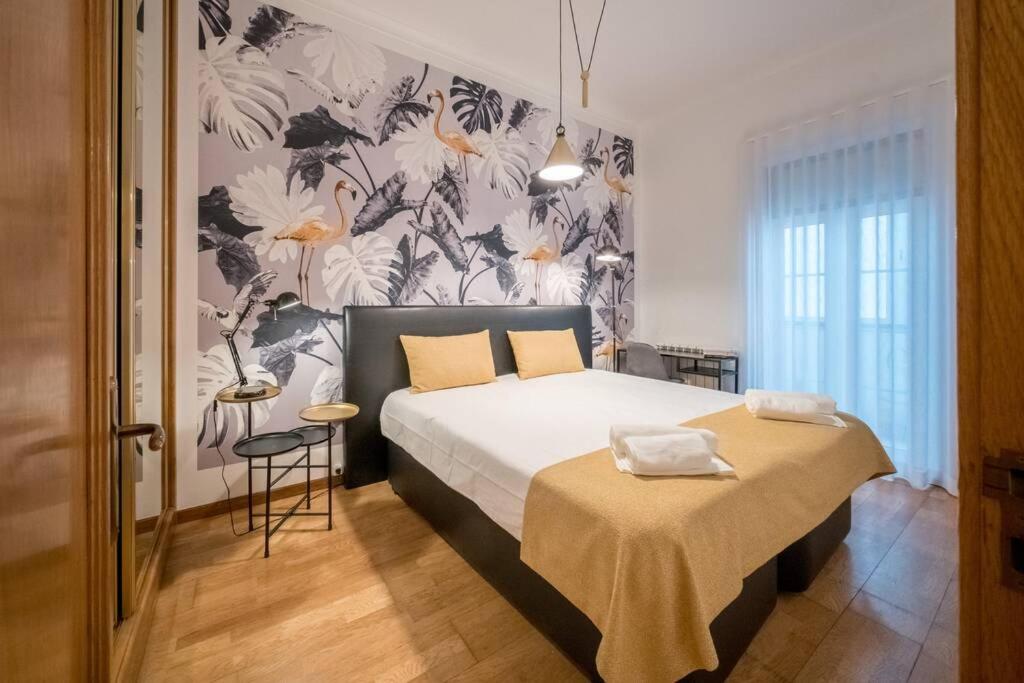 een slaapkamer met een bed en een bloemenmuur bij Beautiful Apartment near the center of Lisbon in Lissabon