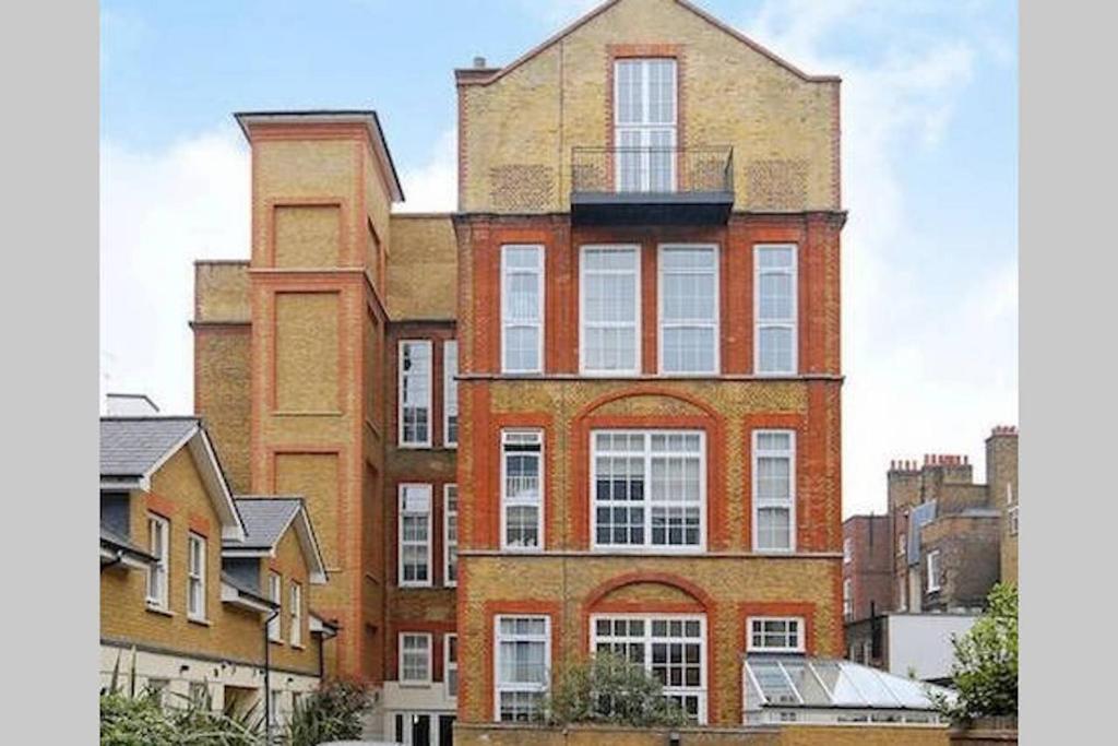 un edificio alto de ladrillo con un balcón en la parte superior. en Central 2-Bed, 2-Bath Sanctuary near Holborn Station, Covent Garden & West End, en Londres