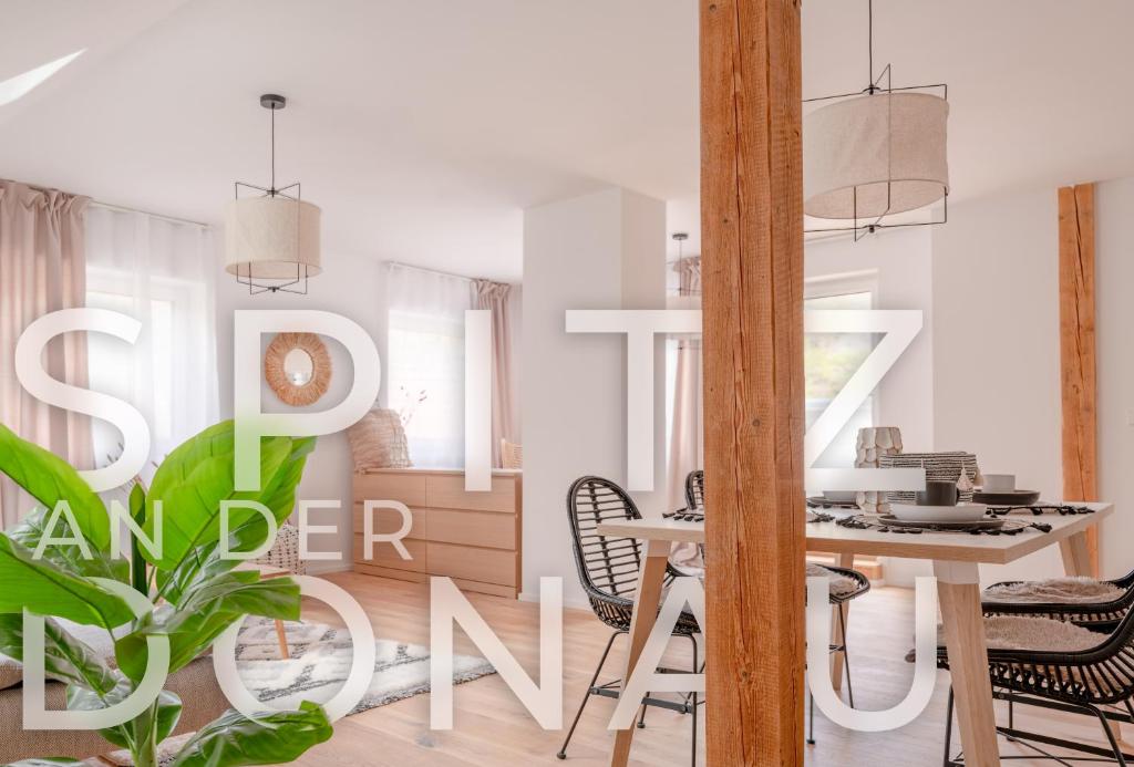 Dach.Loft Spitz in der Wachau في سبيتز: غرفة معيشة مع طاولة وكراسي وغرفة طعام