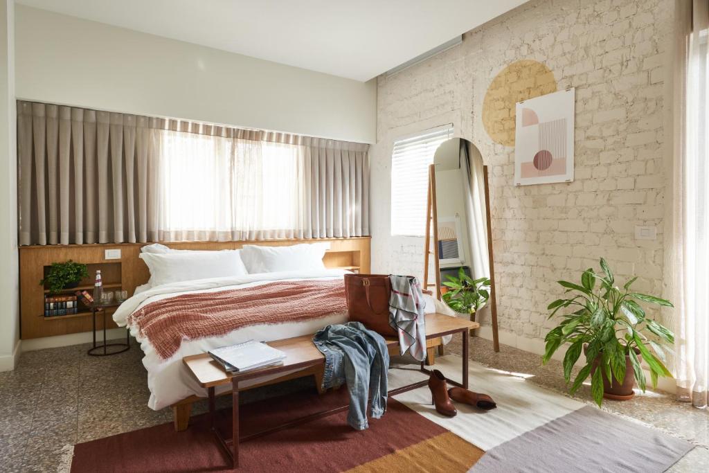 um quarto com uma cama grande e uma janela grande em The Saul Hotel em Tel Aviv