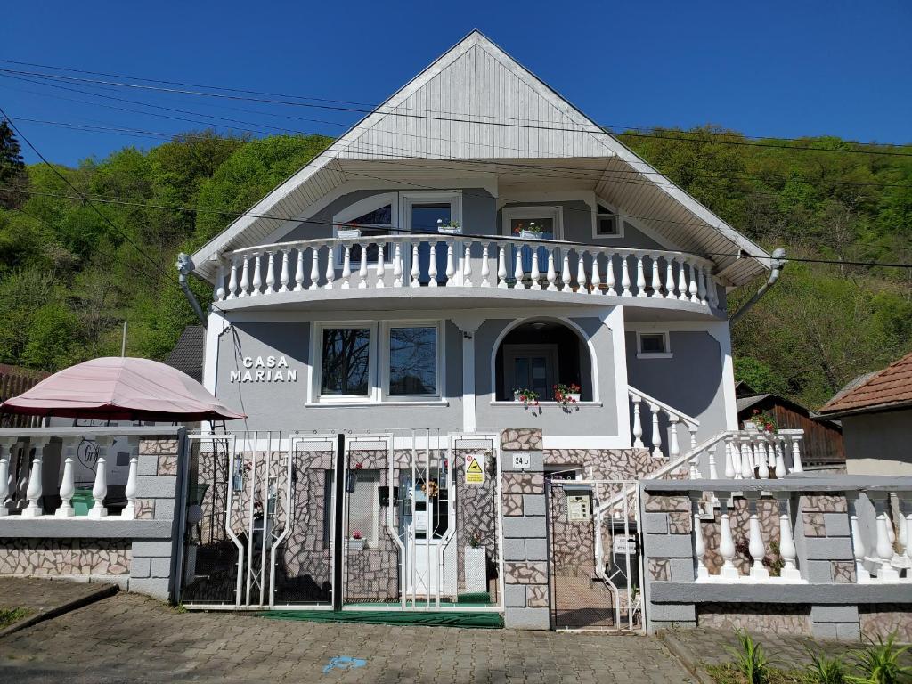uma casa branca com um alpendre e uma cerca em Casa Marian em Sighisoara