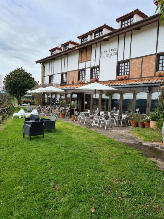 un bâtiment avec des tables et des chaises devant lui dans l'établissement Hotel Colegiata, à Santillana del Mar