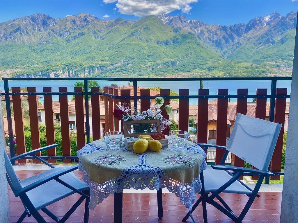 a table with fruit on it with two chairs at Lilla Apartment Vassena in Oliveto Lario