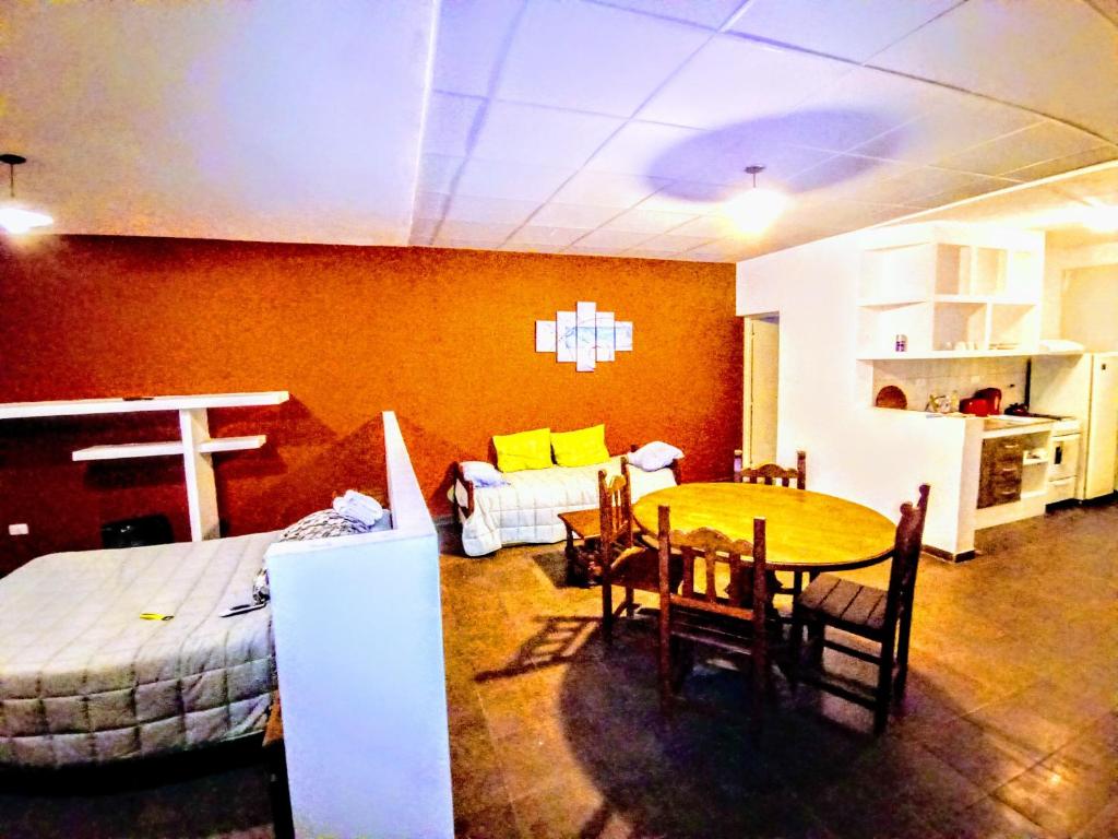 ein Wohnzimmer mit einem Bett, einem Tisch und Stühlen in der Unterkunft Departamento La Morenita in Chilecito