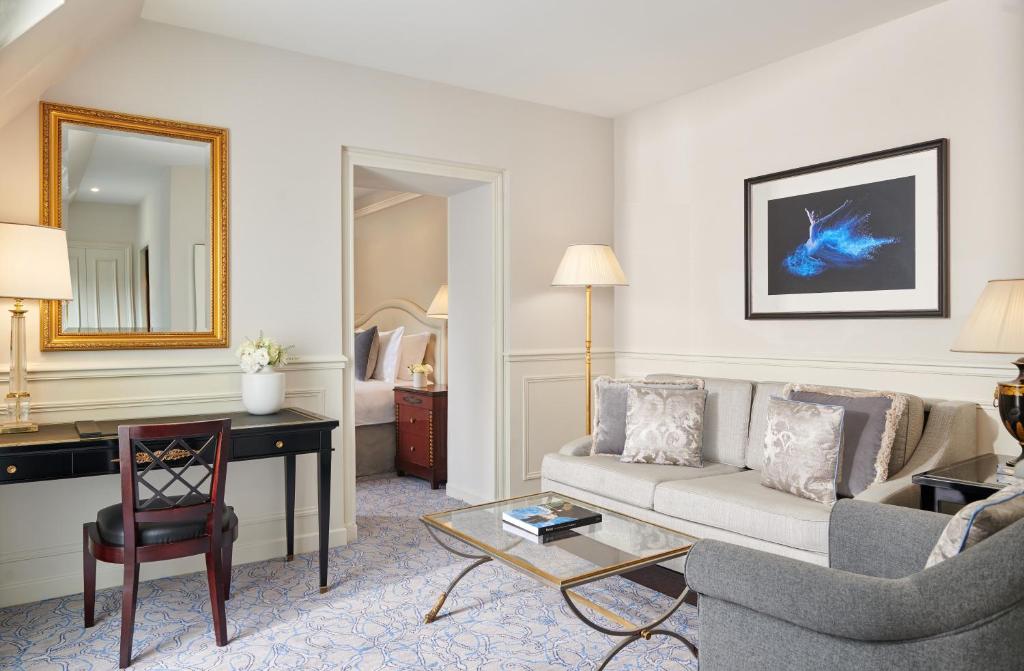 a living room with a couch and a desk in a hotel room at InterContinental Paris Le Grand by IHG in Paris