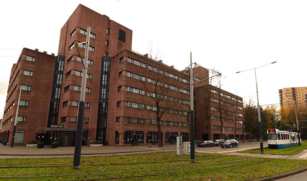 a large brick building with a bus in front of it at XO Hotels Park West in Amsterdam