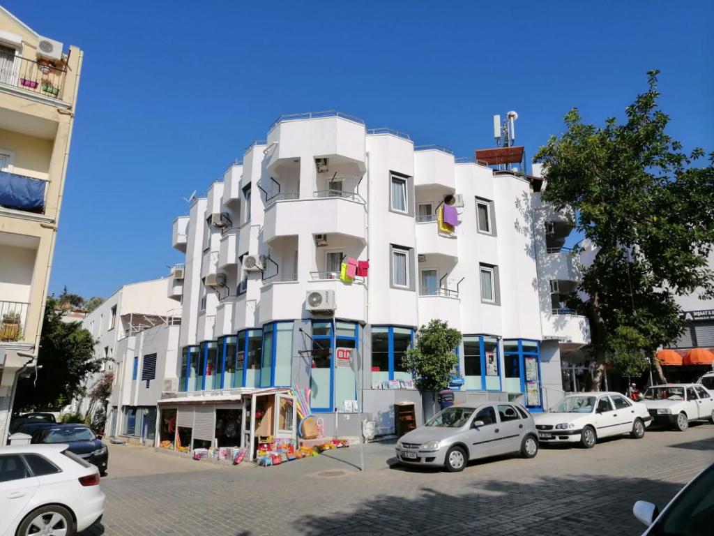 a white building with cars parked in front of it at Mimosa Pension in Kas