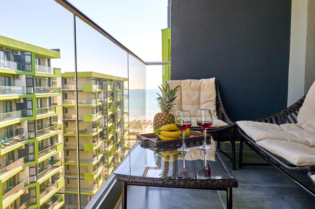 einen Balkon mit Weingläsern und Meerblick in der Unterkunft Sea Shore apartments - Spa n Pools beach resort in Mamaia