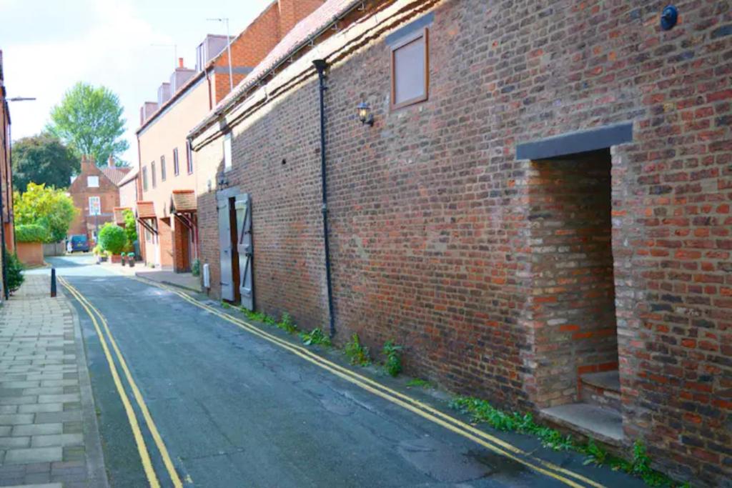 an empty street next to a brick building at Loaf 1 at The Old Granary, Centre of Beverley in Beverley