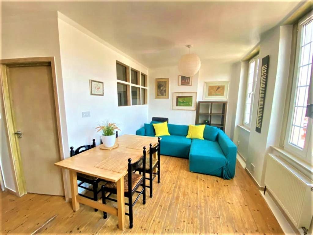 ein Wohnzimmer mit einem blauen Sofa und einem Tisch in der Unterkunft Splendid 1 Bedroom Flat + Terrace (Kentish Town) in London
