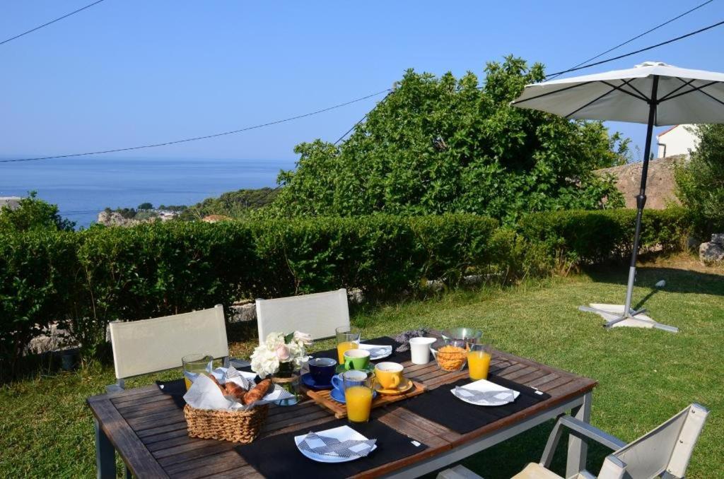 una mesa de madera con comida y una sombrilla en Apartments Brautović en Dubrovnik