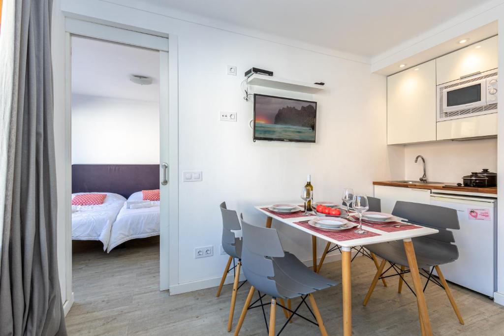a kitchen and dining room with a table and chairs at Apartments Playa in Alcudia