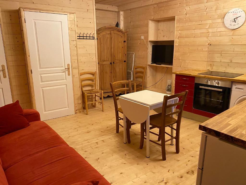 a kitchen and living room with a table and chairs at Studio Huguette in Courchevel