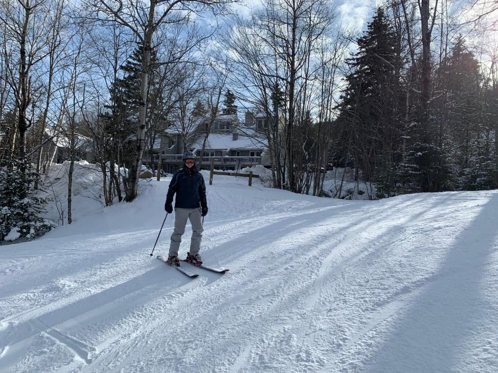 a man is standing on skis in the snow at R5 Completely renovated Bretton Woods condo AC unbeatable SKI-IN SKI-OUT location Fast wifi in Carroll