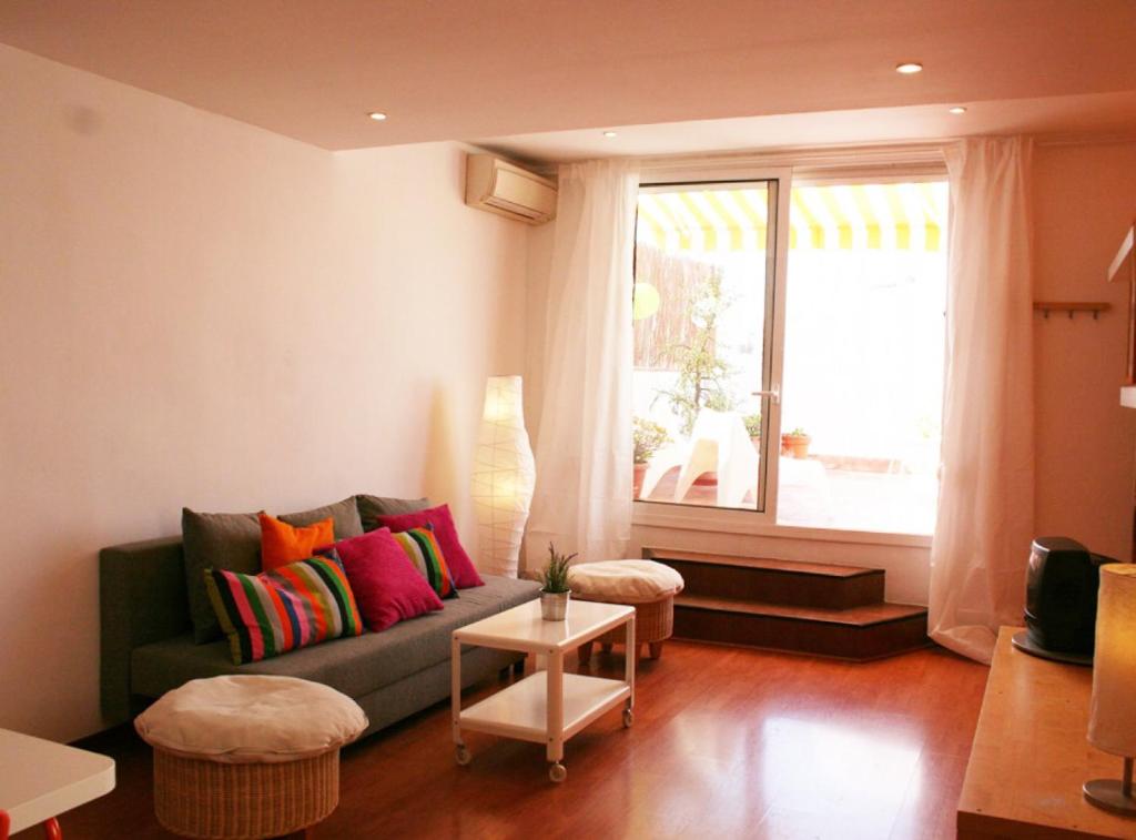 バルセロナにあるLovely apartment with a terraceのリビングルーム(ソファ、窓付)