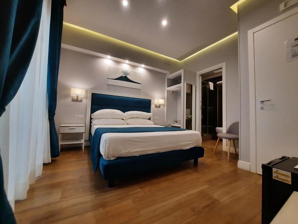 ナポリにあるGea suiteのベッドルーム1室(大型ベッド1台、青いヘッドボード付)