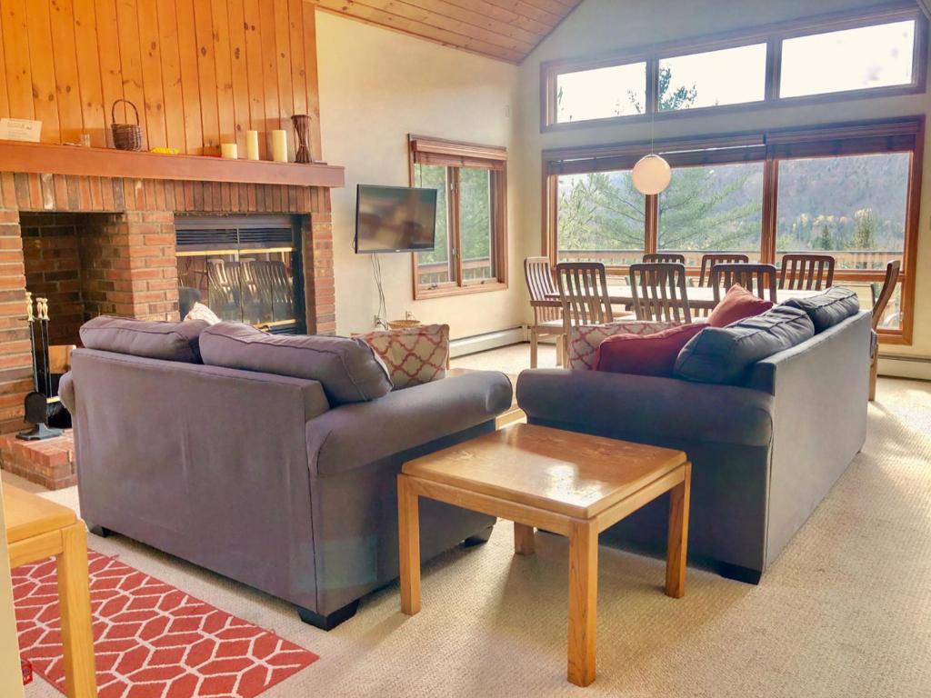 sala de estar con 2 sofás y chimenea en W4 Comfortable and spacious Bretton Woods condo with ski slope views, fireplace and fast wifi!, en Carroll