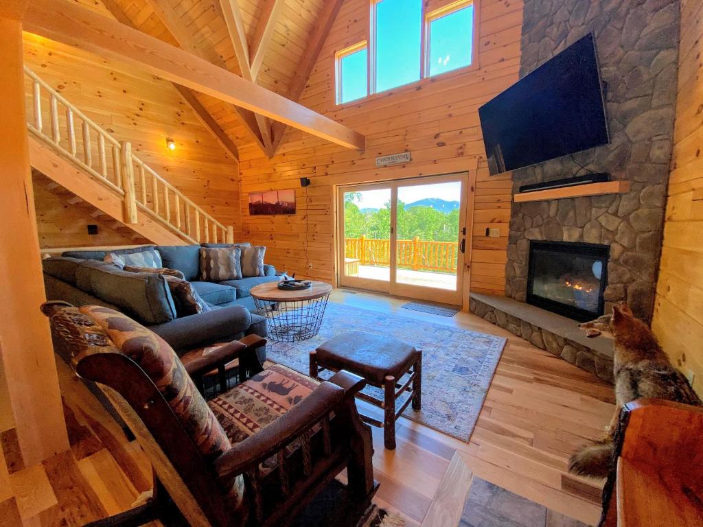 sala de estar con sofá y chimenea en UV Log home with direct Cannon Mountain views Minutes to attractions Fireplace Pool Table AC, en Bethlehem