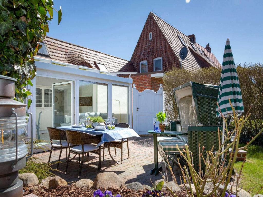 a patio with a table and chairs in a yard at Ferienwohnung Scheunemann in List