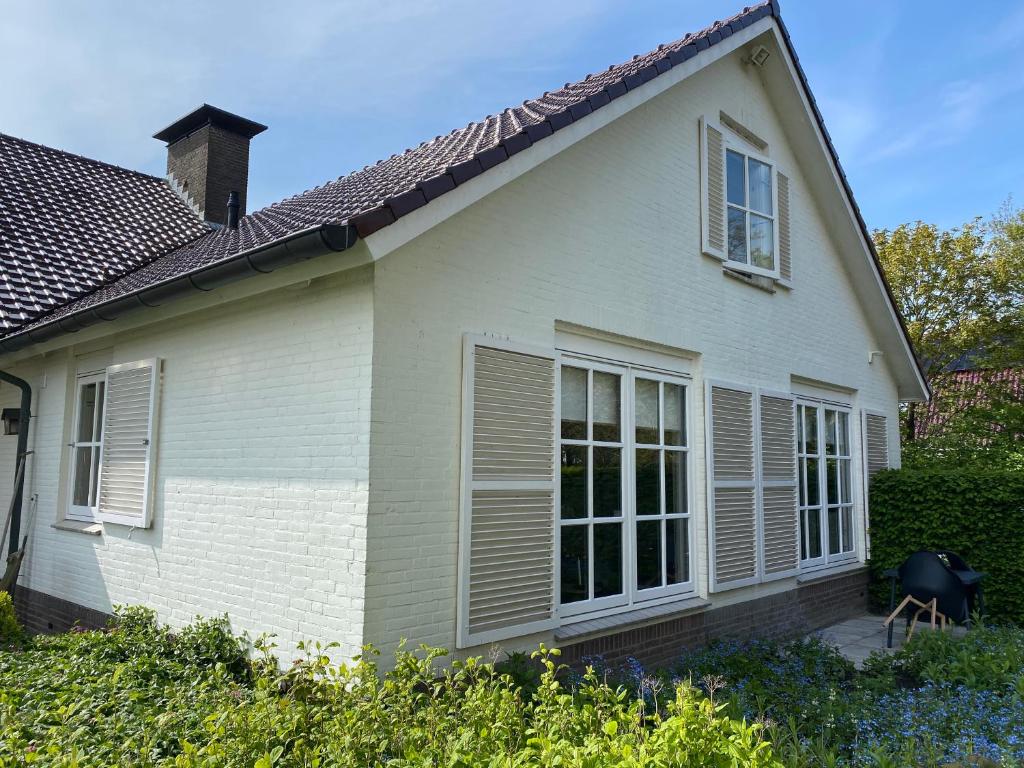 Uma casa branca com persianas. em Stay-Inn Harlingen em Harlingen