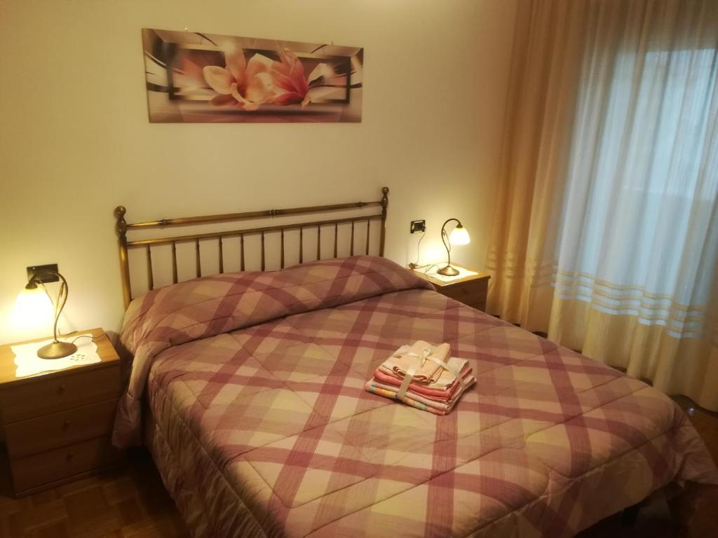 1 dormitorio con 1 cama con 2 toallas en Riccadonna house Residenza Jolly, en Comano Terme