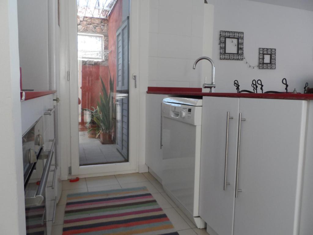 Biała kuchnia ze zlewem i zmywarką do naczyń w obiekcie Apartamento encantador w mieście Las Negras