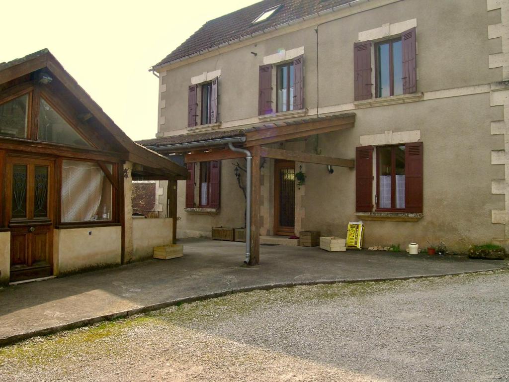 an old house with a driveway in front of it at La Grange aux Roses in Tursac