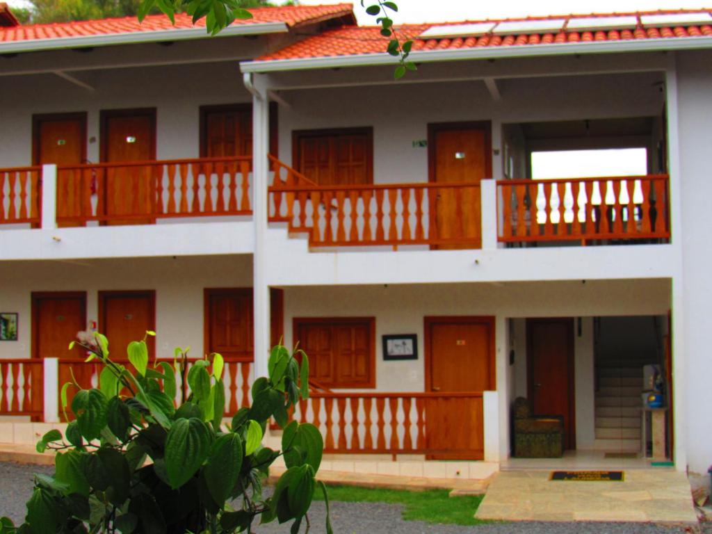 a house with wooden doors and a balcony at Pouso Vovó Laurinda in Pirenópolis