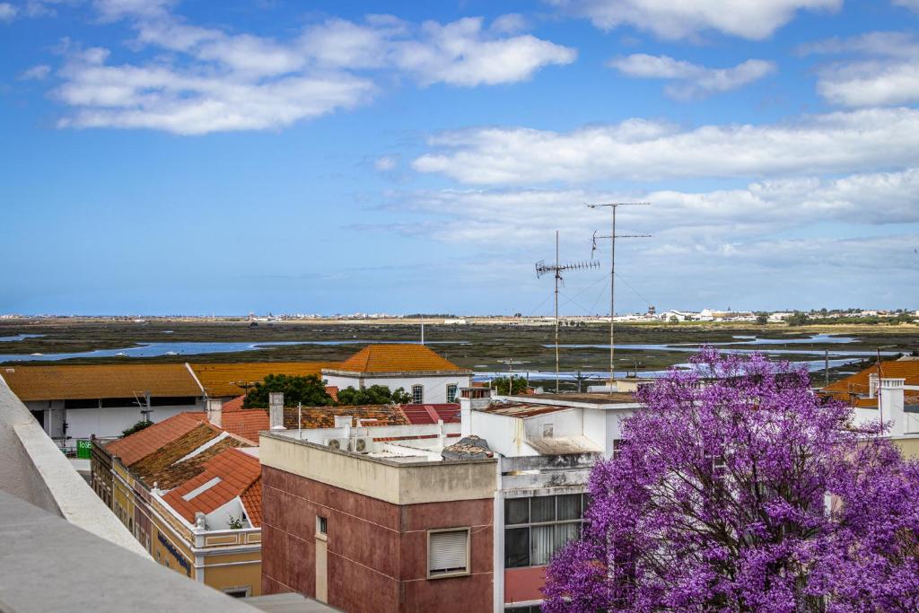 a view of a city with a purple tree at Roots Hotel in Faro