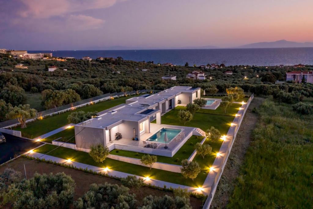an aerial view of a large white house with a pool at Merelia Luxury Villas - Halkidiki in Nea Moudania