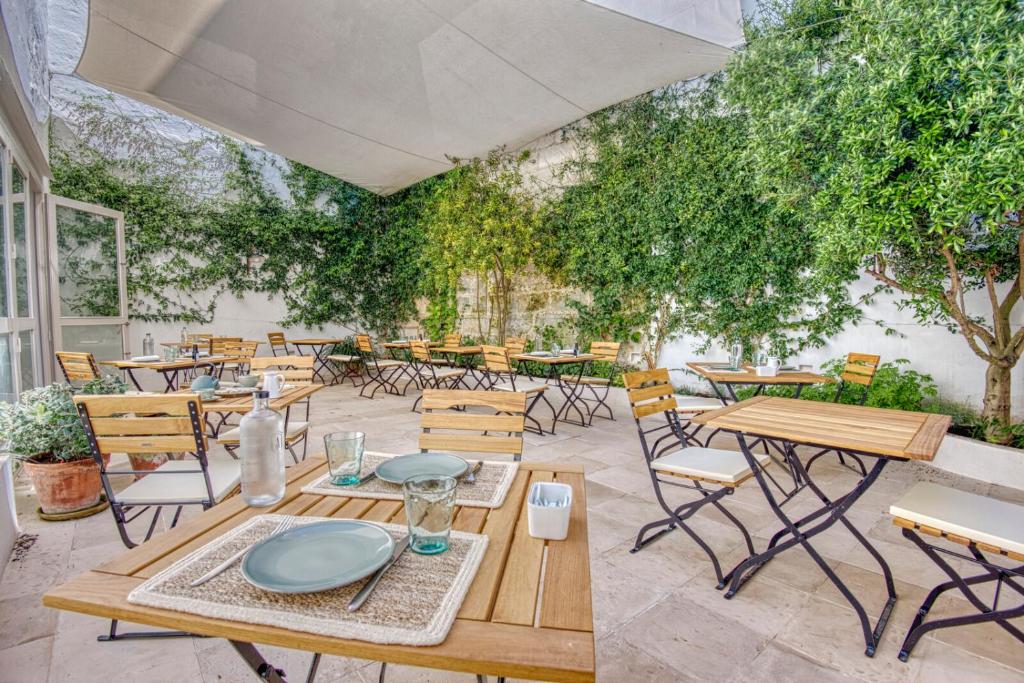 a table with chairs and tables in a garden area at Can Alberti 1740 Boutique Hotel in Mahón