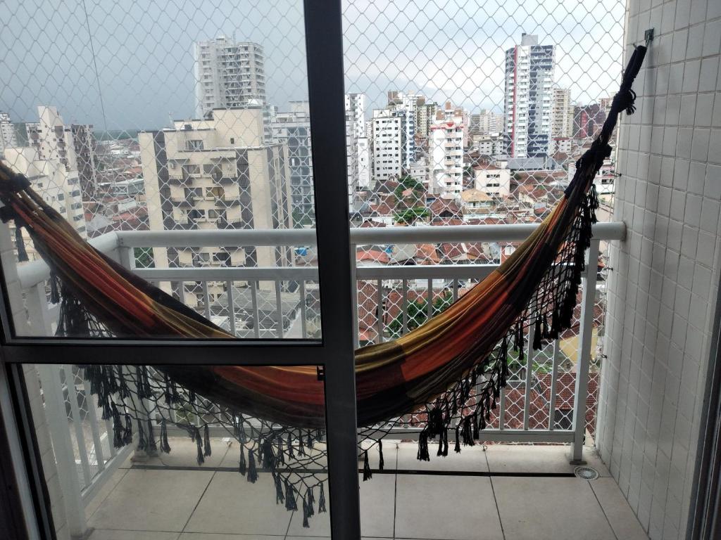 een hangmat op een balkon met uitzicht op de stad bij Lindo Apartamento Novo Praia Grande Ocian 50 Metros da Praia in Praia Grande