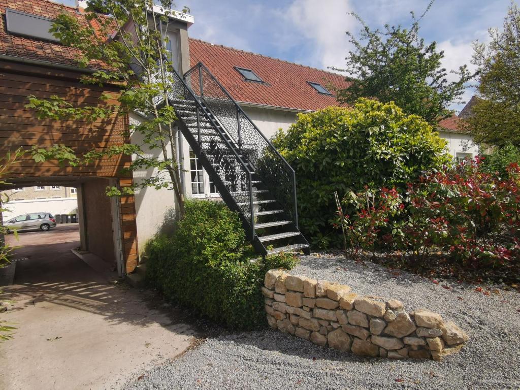 a staircase leading to a house with a stone wall at L'atelier les hortensias in Marquise