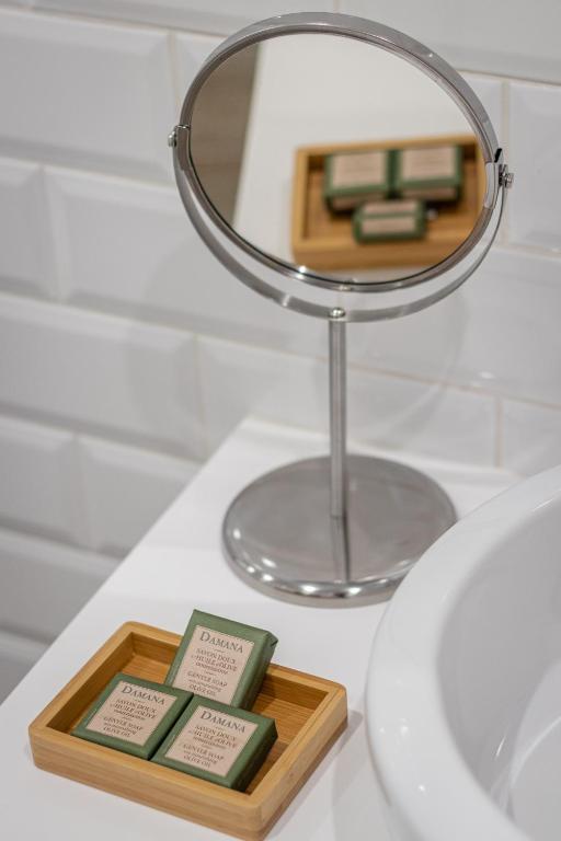 a mirror and a tray of soap on a bathroom sink at Roots Hotel in Faro
