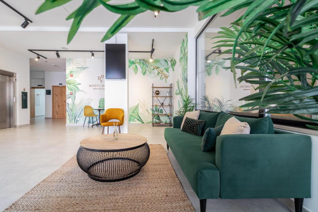 a living room with a green couch and a table at Roots Hotel in Faro