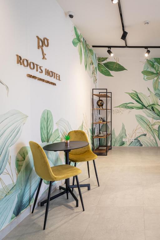 a table and chairs in a room with plants at Roots Hotel in Faro
