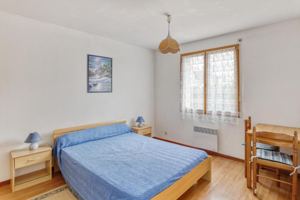 a bedroom with a bed and a chair and a window at Maison de 4 chambres avec jardin clos a Nevez a 1 km de la plage in Névez