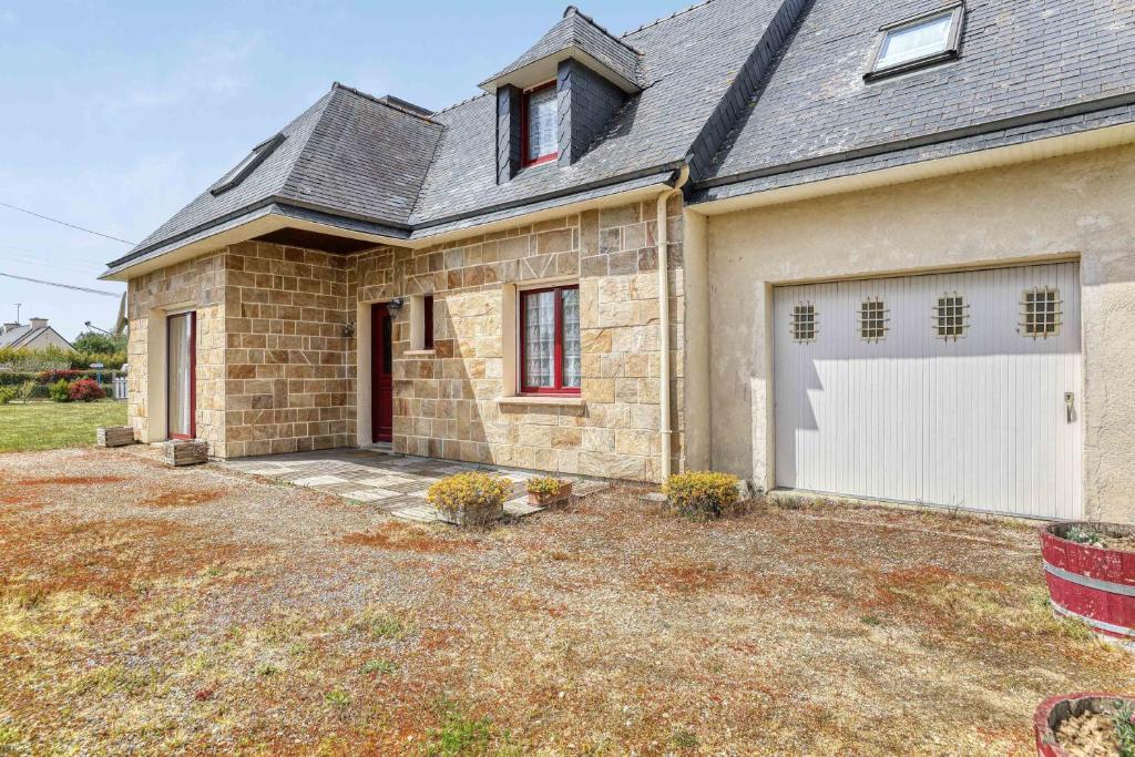 a brick house with a white garage at Maison de 4 chambres avec jardin clos a Nevez a 1 km de la plage in Névez