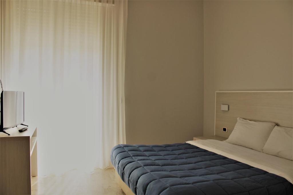 a bedroom with a bed with a blue blanket at Zibibbo Beach Apartments - Trapani in Trapani