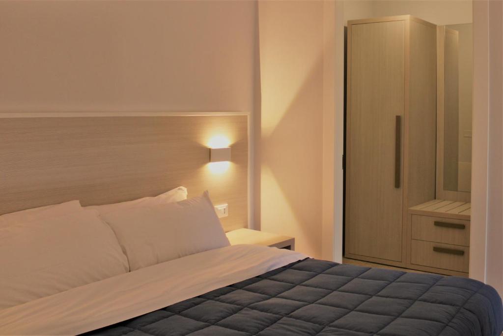 a bedroom with a bed and a cabinet in it at Zibibbo Beach Apartments - Trapani in Trapani